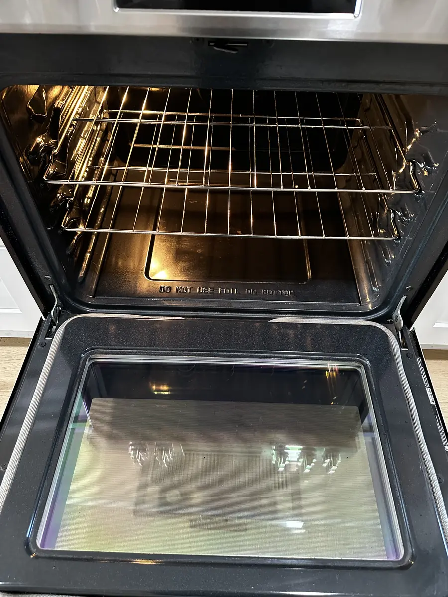 The same oven with clear door glass and clean racks after cleaning
